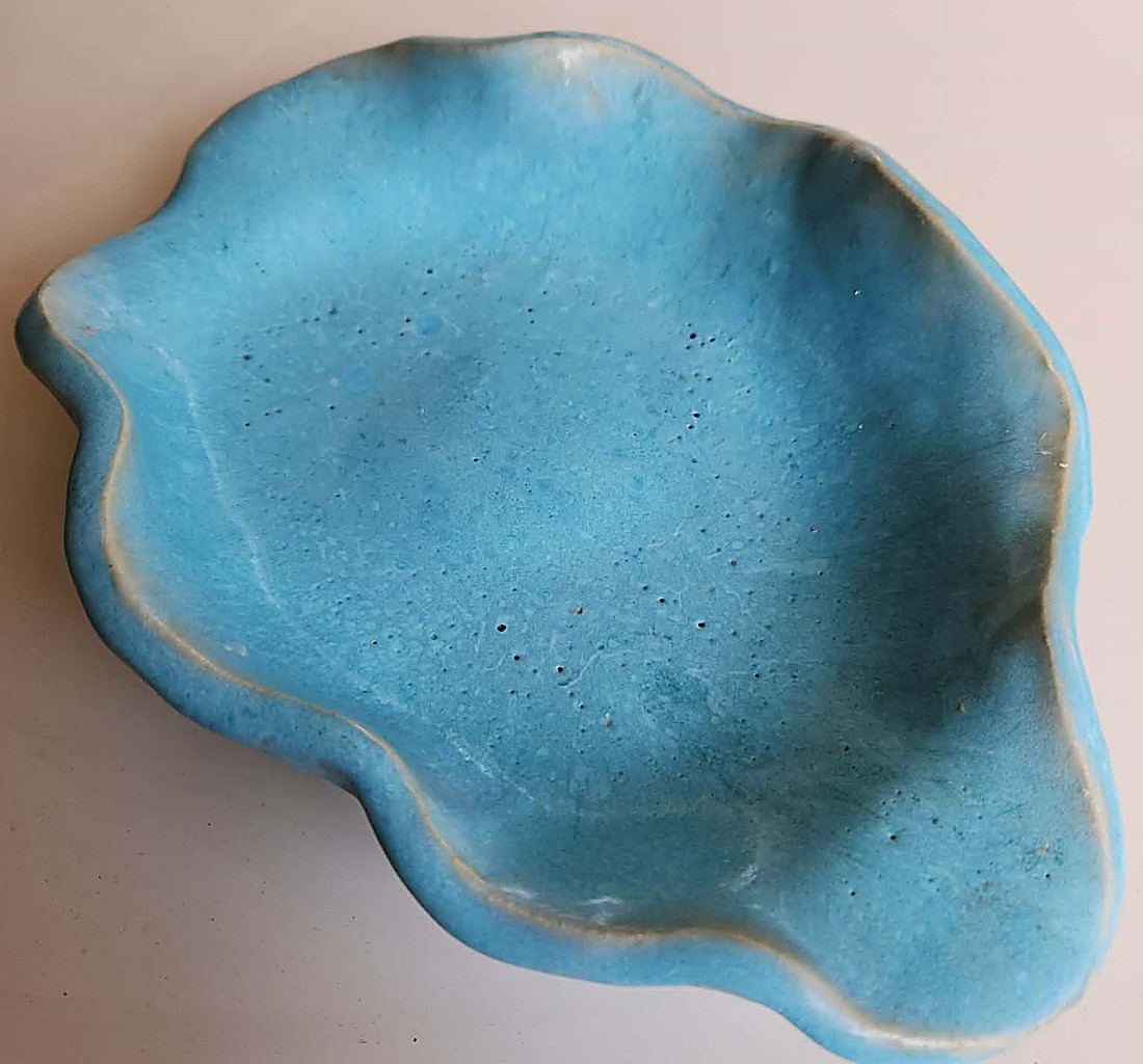 A ruffled, organically shaped dish brushed in Anchor Aqua — a pale turquoise blue glaze with darker blue pooling around the folded, wavy rim