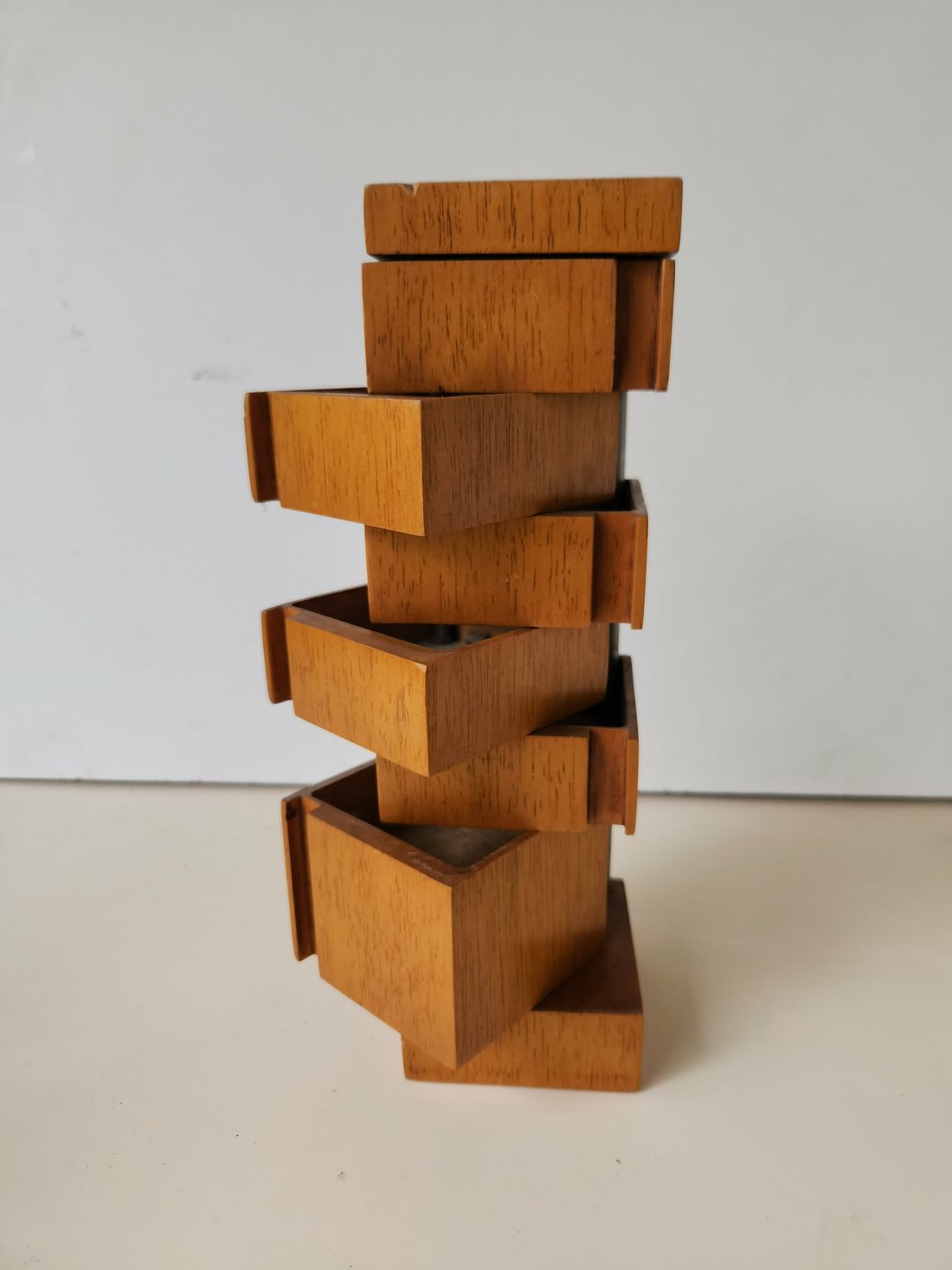 The 1:5 scale model of the cabinet, its drawers swung open to alternate sides &mdash; left, right, left, right up the height of the stack &mdash; so the timber boxes zigzag around the central column above a canted base