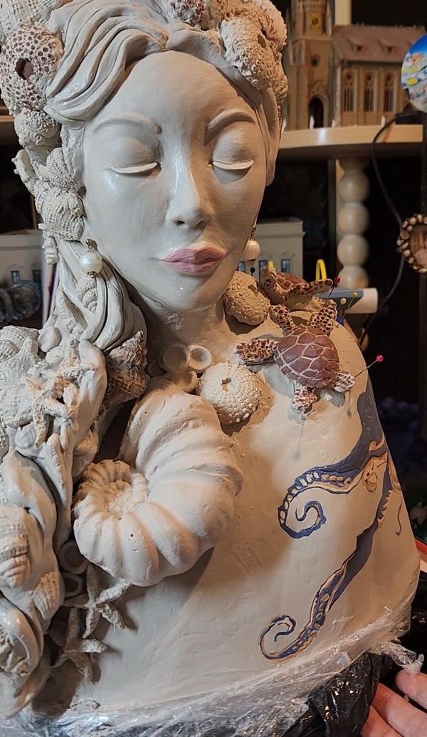 The Marine Biologist — shells through her hair, turtles at her shoulder and a hand-glazed octopus across the figure