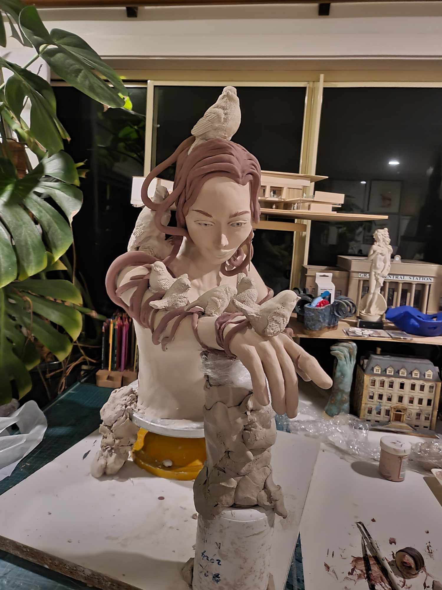 The Ornithologist — a bird on her head, coiled flowing hair, and small birds along her outstretched arm