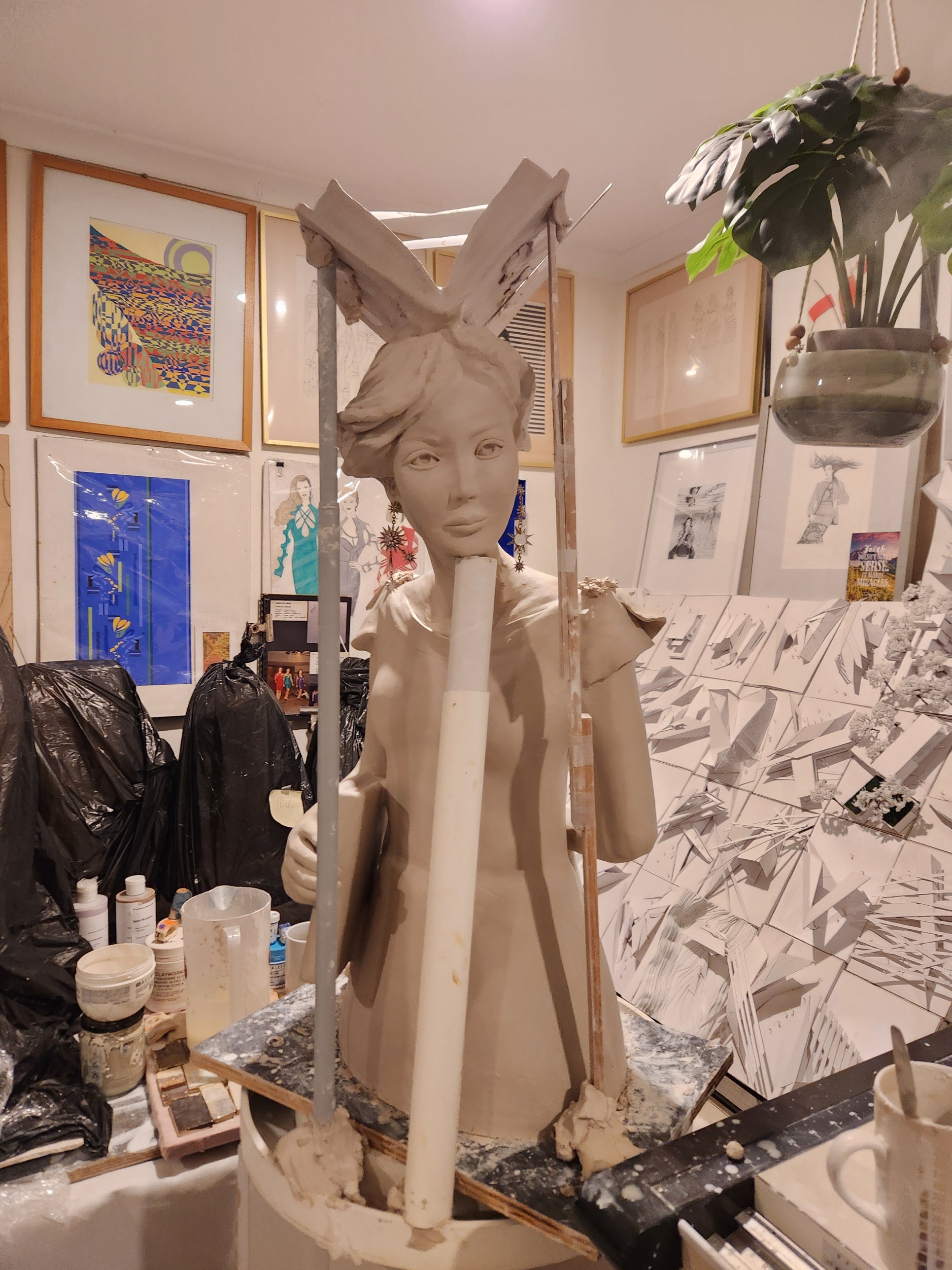 The Teacher in greenware &mdash; an open clay book above her hair, a book held in one hand