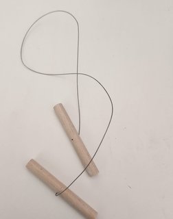 A cutting wire strung between two wooden toggle handles